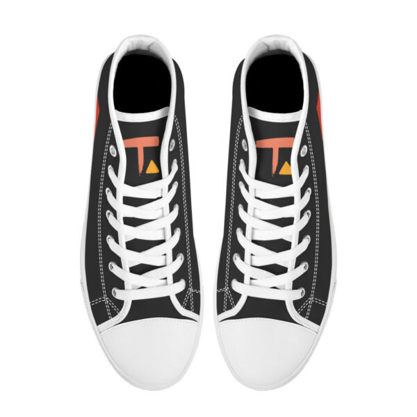 Top-down view of the Etel sneakers, showing white laces, black tongue, and a bold abstract 'T' logo in warm tones on the insole.