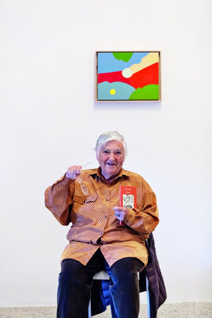 Etel Adnan in front of one of her paintings